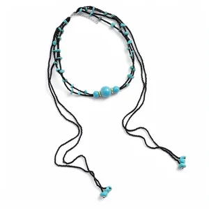 Elegant multi-layer necklace with turquoise beads and black tassels on white background