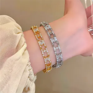 Close-up of 18k gold plated oval bracelets with sparkling zircons on a wrist