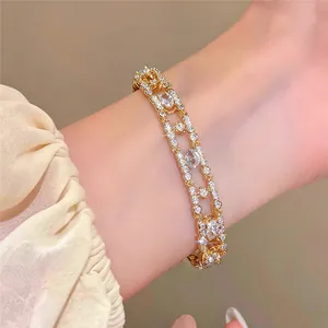 Close-up of 18k gold plated bracelet with zircon oval charms worn on female wrist