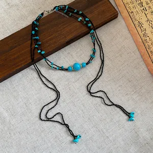 Detailed view of bohemian multi-layer necklace with turquoise beads and long tassels