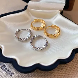 Detailed view of geometric 18k gold plated hoop earrings inlaid with small zircon stones
