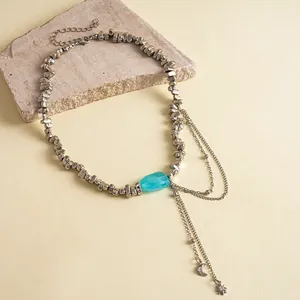 Zilveren onregelmatige kralenketting met turquoise steen en maan en ster kwastjes