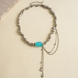 Detailopname van onregelmatige metalen kralen en maanster kwastjes van deze ketting