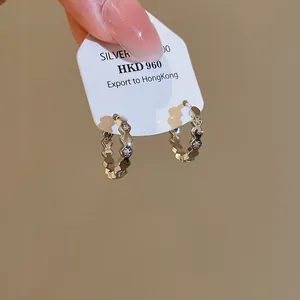Detailed view of 18k gold plated geometric hoop earrings with sparkling zircon stones