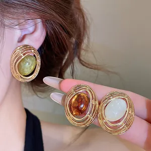 Detailansicht von Vintage-Harzohrringen in Golddrahtoptik in drei eleganten Farben.