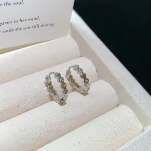 Close-up of 18k gold plated hoop earrings with clear zircon stones in a box.