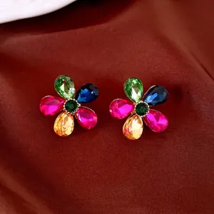 Colorful crystal flower stud earrings with teardrop petals on elegant brown fabric