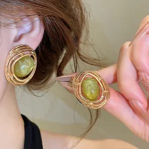 Detailansicht von Vintage-Ohrringen in Ellipsenform mit grünem Marmor-Harzstein.