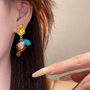 Vintage Maillard style tassel earrings featuring turquoise and resin stones on model's ear