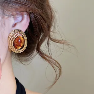 Detailaufnahme eines vintage ovalen Harz-Hohlsteckers mit edlem goldenem Finish.