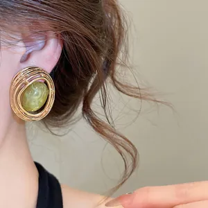 Detailansicht eines Vintage-Ohrrings aus Harz mit vergoldetem, hohlem Spiraldesign.