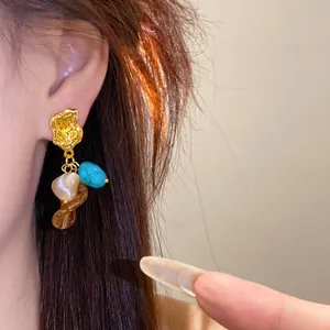 Detailed view of vintage Maillard style earring with turquoise and amber stones