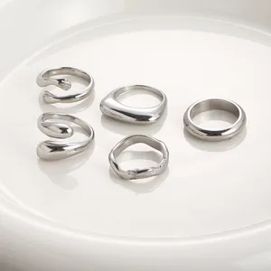 Dettaglio di cinque anelli minimalisti in acciaio inossidabile argento su un piatto