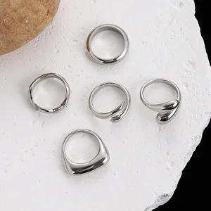 Vista dettagliata di cinque anelli minimalisti in acciaio inossidabile argento su pietra