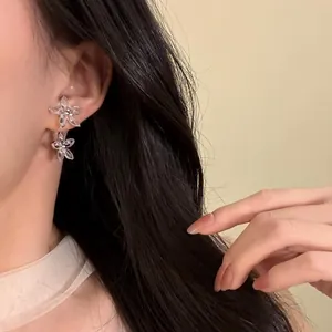 Detailansicht der funkelnden Zirkonia-Blumen-Ohrstecker an einem eleganten Damenohr