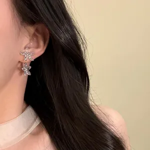 Detailaufnahme eines Models mit eleganten transparenten Blumenohrsteckern mit Zirkonia