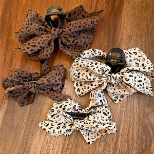 Primer plano de pinzas para el cabello con lazo de tela de leopardo retro, detalles