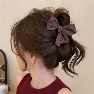 Detalle de una pinza para el pelo vintage con lazo de leopardo en una coleta alta