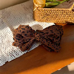 Primer plano detallado de una pinza para el pelo vintage con un lazo de tela de leopardo
