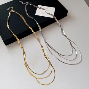 Eine minimalistische dreilagige Metall-Schlangenkette in Gold- und Silberoptik
