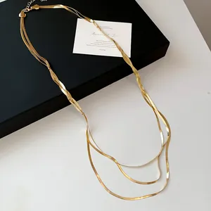 Detailaufnahme der Textur einer dreilagigen goldenen Schlangenkette für Damen