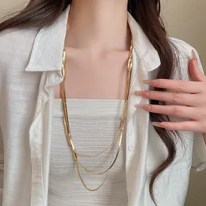 Nahaufnahme der dreilagigen goldenen Schlangenkette mit metallischem Glanz und Textur.