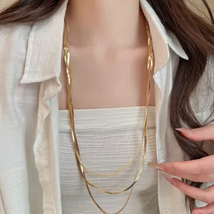 Elegante dreilagige goldene Schlangenkette an einem Modell für einen minimalistischen Look.