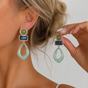 Vista detallada de pendientes geométricos de acrílico jaspeado vintage en una modelo