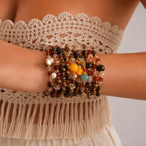 Close-up of stacked vintage tiger eye and glass beaded bracelets on a model's wrist