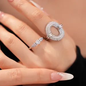 Macro view of a sparkling zircon hollow circle ring set on a hand with manicure.
