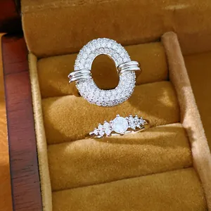 Detailed close-up of luxury zircon pavé hollow statement ring and classic solitaire ring.