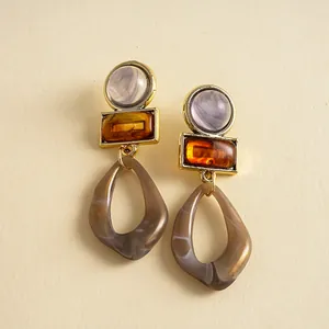 Detalle de pendientes colgantes geométricos vintage de acrílico con texturas de resina