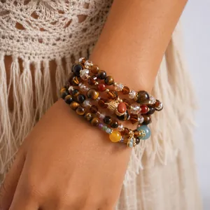 Close-up view of vintage bohemian tiger eye and glass beaded bracelets on model's wrist