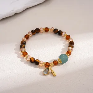 Detailed view of vintage tiger eye and glass beaded bracelet with gold charm