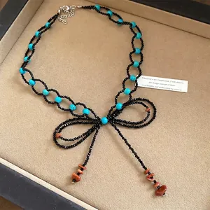 Collana di perline fatta a mano con pietre turchesi e elegante design a fiocco