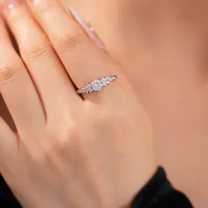 Elegant close-up shot of a silver-colored ring with a round central zircon on a finger