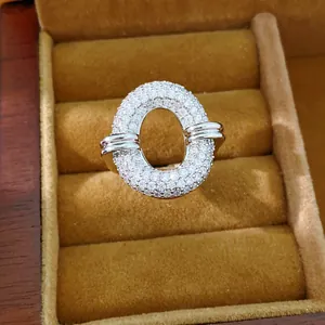 Detailed close-up of a shimmering silver-tone oval hollow ring pavé-set with clear zirconia