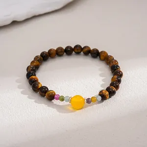Close-up of tiger eye beaded bracelet with a central yellow bead in retro style