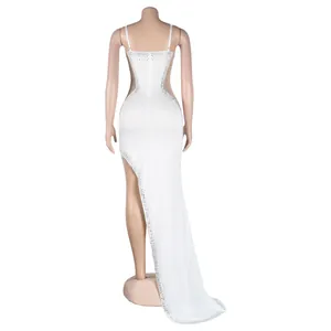 Back view of a white sexy rhinestone evening dress with high slit and sheer mesh panels.