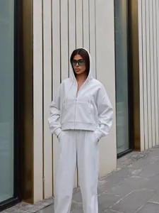 Street style view of a light gray two-piece tracksuit with zip-up hoodie and pants