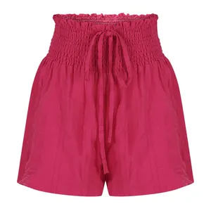 Detailed macro view showing the smocked waistband and fabric texture of pink shorts