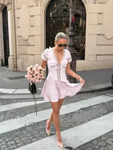 French style pink V-neck lace mini dress with puff sleeves shown on model in street scene