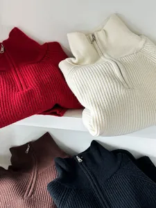 Dettaglio ravvicinato di maglioni a coste con mezza zip in vari colori diversi.