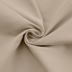 Hoogwaardige close-up van beige twill-stoftextuur voor een elegante Franse overhemdjurk.