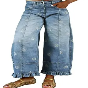 Detail of light blue floral print jeans with ruffled hems and stitched panels.
