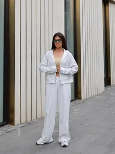 Street style shot of a grey two-piece tracksuit with hooded zip jacket and pants