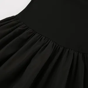 Close-up of elegant black Hepburn style dress showing pleated waist and fabric detail