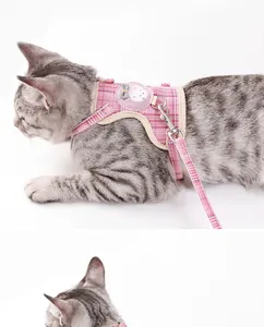 Detail view of pink plaid cotton cat harness featuring a cute cartoon badge and leash.