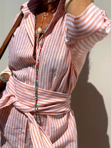 Close-up of vibrant orange and white striped lapel shirt dress with a stylish waist tie