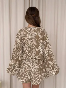Vista posteriore di un completo due pezzi in maglia marrone con ricami floreali bianchi